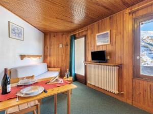 a room with a bed and a table and a television at Apartment Le 2100 A et B-1 in Tignes