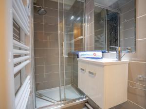 ein Bad mit einer Dusche mit einem Waschbecken und einer Glastür in der Unterkunft Apartment Le Capitole-8 by Interhome in Fréjus