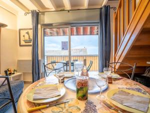 einen Tisch mit Tellern und Weingläsern sowie ein Fenster in der Unterkunft Apartment Le Capitole-8 by Interhome in Fréjus