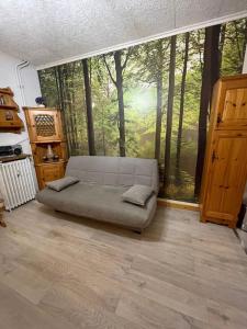 a room with a couch in front of a forest mural at Apartment Le Savoisien by Interhome in Chamonix