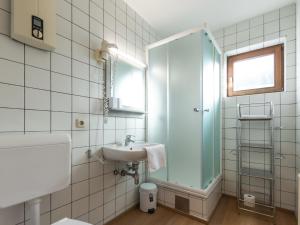 a bathroom with a sink and a glass shower at Apartment Alpenchalets - ZSE204 by Interhome in Zell am See