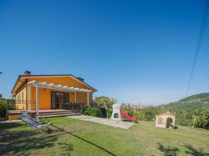 Santa LuciaにあるHoliday Home La Casa al Monte by Interhomeの小さな黄色の家(遊び場、滑り台付)