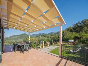 Santa LuciaにあるHoliday Home La Casa al Monte by Interhomeの屋根付きのパティオ(テーブル、椅子付)