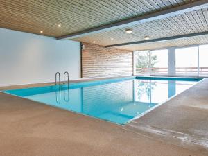 een zwembad in een gebouw met een binnenzwembad bij Apartment Hameau D001 by Interhome in Les Collons