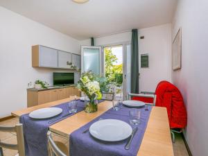 comedor con mesa y sillas y cocina en Apartment Robinia-Pinetine-2 by Interhome, en Duna Verde