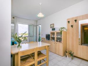 een keuken met een houten tafel en een eetkamer bij Apartment Albatros-1 by Interhome in Caorle