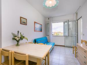 a living room with a table and a blue couch at Apartment Albatros-1 by Interhome in Caorle