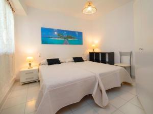 1 dormitorio con 1 cama blanca grande y 2 lámparas en Apartment Playsol-2 by Interhome, en Calpe