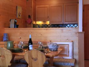 drewniany stół z butelką wina i kieliszkami w obiekcie Apartment Grand-Hôtel B35 by Interhome w mieście Villars-sur-Ollon