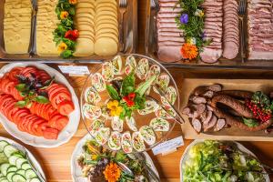 a table filled with different types of food on plates at Bacówka Biały Jeleń in Iwkowa