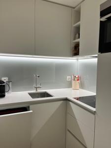 苏尔勒吉Apartment Residenza Chesa Margun 13-4 by Interhome的带白色橱柜和水槽的白色厨房 更多17张照片