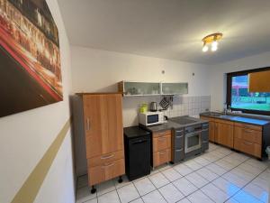 eine Küche mit einem Herd und einer Mikrowelle in der Unterkunft Apartment Ferienapartments Adenau-1 by Interhome in Adenau