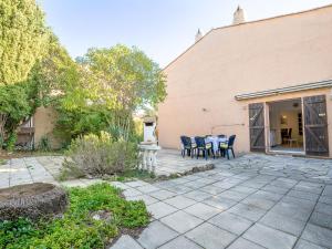 a patio with a table and chairs in front of a building at Holiday Home Les Troenes by Interhome in Fréjus