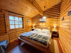 1 dormitorio con 1 cama en una cabaña de madera en Chalet Birdieferienhaus by Interhome, en Leisel