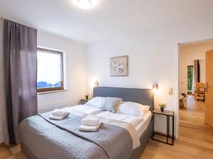 a bedroom with a large bed with two towels on it at Apartment Alpenchalet - ZSE200 by Interhome in Zell am See