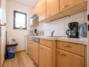 湖畔捷爾的住宿－Apartment Alpenchalet - ZSE200 by Interhome，厨房配有木制橱柜、水槽和窗户。