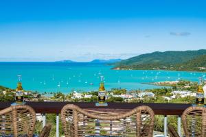 a view of a bay with two chairs and bottles of beer at South Hamptons Beach House in Airlie Beach