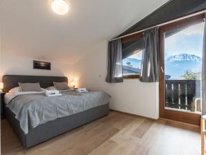 a bedroom with a bed and a large window at Apartment Alpenchalets - ZSE203 by Interhome in Zell am See