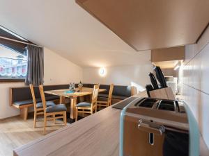 a kitchen and dining room with a table and chairs at Apartment Alpenchalets - ZSE202 by Interhome in Zell am See