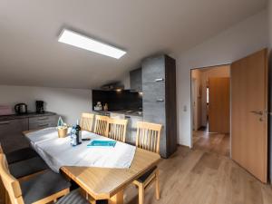 a kitchen and dining room with a wooden table and chairs at Apartment Alpenchalets-4 by Interhome in Zell am See +41 photos