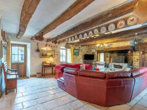 ein Wohnzimmer mit einem roten Sofa und einem Steinkamin in der Unterkunft Holiday Home La Duchesse - RHU352 by Interhome in Sarzeau