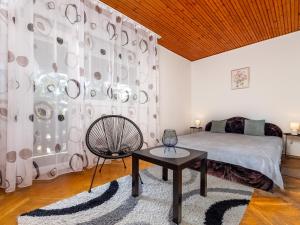 ein Schlafzimmer mit einem Bett, einem Tisch und einem Stuhl in der Unterkunft Holiday Home Brasse by Interhome in Balatonkeresztúr
