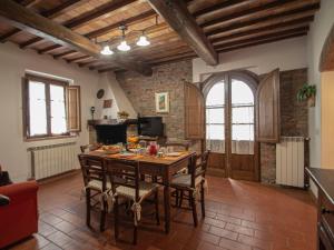 una cucina e una sala da pranzo con tavolo e sedie in legno di Apartment Michelangelo by Interhome a Montaione