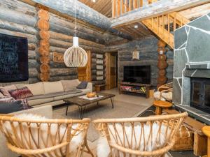 a living room with a couch and a fireplace at Holiday Home Kantolan veska by Interhome in Ruka