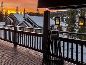 a bench on the deck of a house in the snow at Holiday Home Vuosselinkulma 4 by Interhome in Ruka