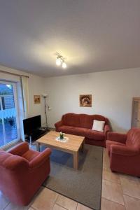 - un salon avec deux canapés rouges et une table basse dans l'établissement Apartment Osterriede by Interhome, à Norddeich