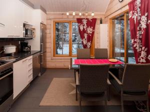 kuchnia ze stołem i krzesłami w małym domku w obiekcie Holiday Home Ihtingin koskikara by Interhome w mieście Ruka