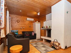 a living room with a couch a table and a refrigerator at Holiday Home Hillakumpu by Interhome in Nissi