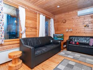 a living room with two leather couches and a television at Holiday Home Hillakumpu by Interhome in Nissi