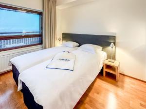 1 dormitorio con 1 cama blanca grande y ventana en Holiday Home Ski chalets 6203- during winter season 2 by Interhome en Ylläs