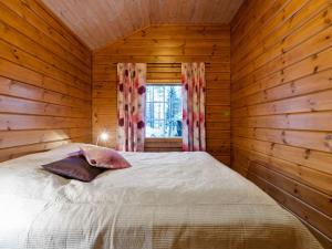 ユッラスヤルヴィにあるHoliday Home Lomaylläs maja- palovaarankaarre 6 a by Interhomeの木造キャビン内のベッド1台が備わるベッドルーム1室を利用します。