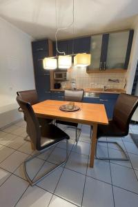une cuisine avec une table en bois et des chaises noires dans l'établissement Apartment Witthuus-Baltrum by Interhome, à Norddeich