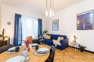 salon ze stołem i niebieską kanapą w obiekcie SuperApart Tarchomińska apt 24 w Warszawie