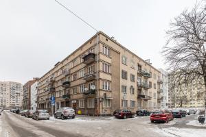 duży budynek z samochodami zaparkowanymi na parkingu w obiekcie SuperApart Tarchomińska apt 24 w Warszawie