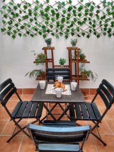 een tafel met vier stoelen en een tafel met eten erop bij CDZ - San Telmo, apartamentos con terraza in Cádiz