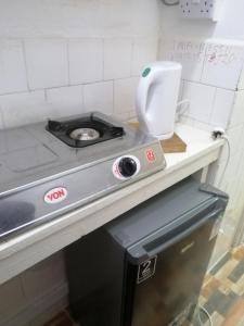 a kitchen counter with a stove and a sink at Mombasa City Center Studio in Mombasa