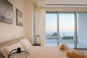 Sea Pearl Beachfront Villas - Breeze في أيا نابا: غرفة نوم عليها سرير وفوط
