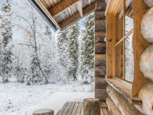 アカスロンポロにあるHoliday Home Kopara b 8- finnday by Interhomeの雪に覆われた木々が茂る丸太小屋の窓