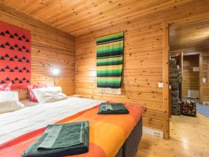 アカスロンポロにあるHoliday Home Elmeri by Interhomeの木製の部屋にベッド1台が備わるベッドルーム1室があります。