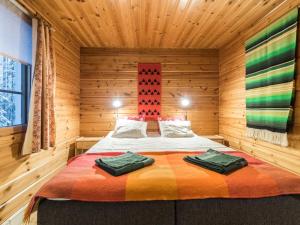 アカスロンポロにあるHoliday Home Elmeri by Interhomeの木造キャビン内のベッド1台が備わるベッドルーム1室を利用します。