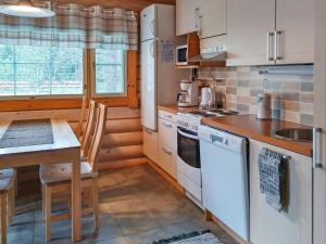 アカスロンポロにあるHoliday Home Kurjenpuola by Interhomeのキッチン(白い家電製品、テーブル、椅子付)