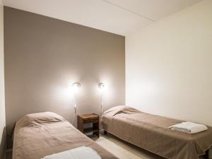 アカスロンポロにあるHoliday Home Yllästar 3 as 605 by Interhomeのベッド2台 壁にランプ2つが備わる客室です。