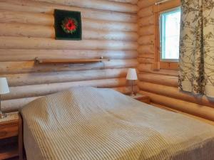 a bedroom with a bed in a log cabin at Holiday Home Kurjenpuola by Interhome in Äkäslompolo