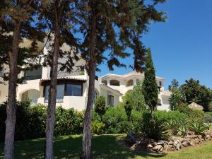 una gran casa blanca con árboles en el primer plano en Vista Hermosa Marbella en Marbella