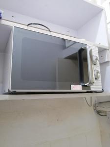 a microwave oven sitting on a shelf in a kitchen at Mombasa City Center Studio in Mombasa