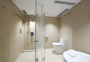a bathroom with a shower and a toilet and a sink at Holiday Inn Golden Mile, an IHG Hotel in Hong Kong